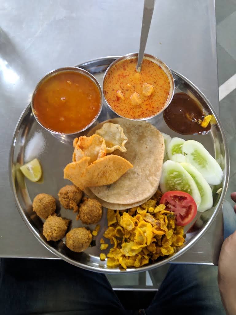 A visitor’s thali with flatbread, vegetables and bowls of food